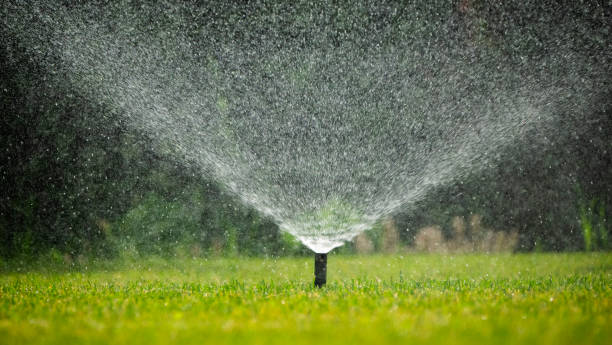istock Sprinkler system distributing water over a lush, green lawn on a bright, sunny day. 2155297175