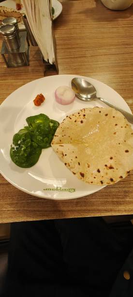 istock Chapati or Indian flat bread, which is a traditional and popular vegetarian breakfast or lunch item, with palak paneer and onion and pickles as side dishes 2155297475