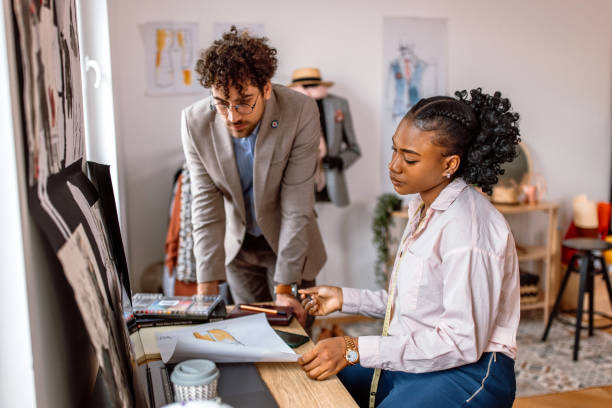 istock Fashion designer and tailor working together in clothes design studio 2155298732
