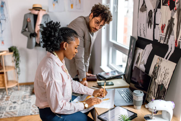 istock Fashion designer and tailor working together in clothes design studio 2155298776
