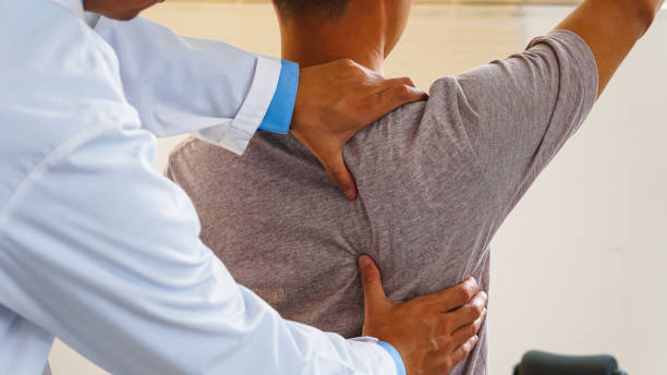 istock Physiotherapist or medical professional doing physiotherapy on the back scapula and back injury of male athlete patient stretching and exercise cause pain rehabilitation therapy, health insurance. 2155301183