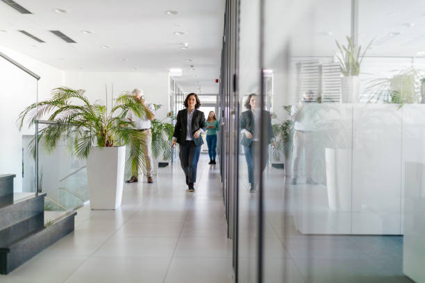 istock Colleagues greeting each other in the office hallway 2155302083