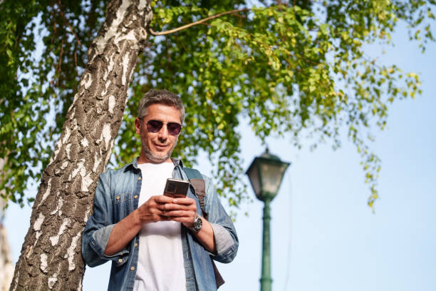 istock Man walking in a city, using mobile phone 2155303094