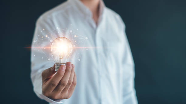 istock Idea innovation and inspiration concept.Hand of man holding illuminated light bulb, Idea innovation and inspiration concept.  creativity with bulbs that shine glitter, Concept for success. 2155307849