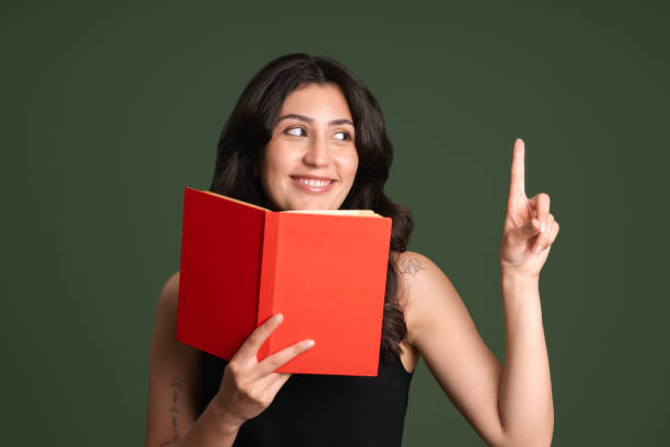 Young woman holding an old book to his face
