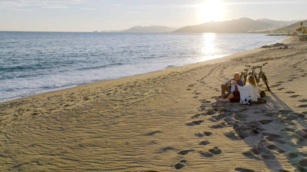 istock mature couple enjoying drinks on beach 2155313808