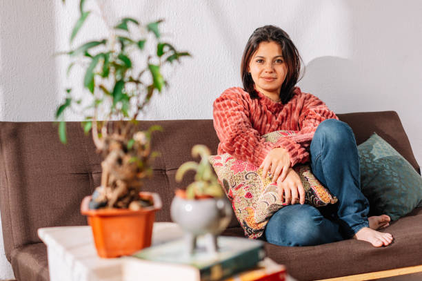 istock Latin woman on the couch looking at the camera 2155315212