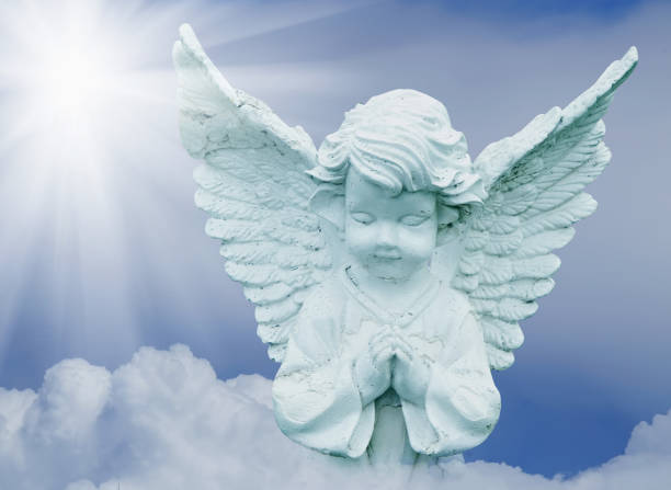 istock Little beautiful angel praying on a cloud in the sky. 2155315952