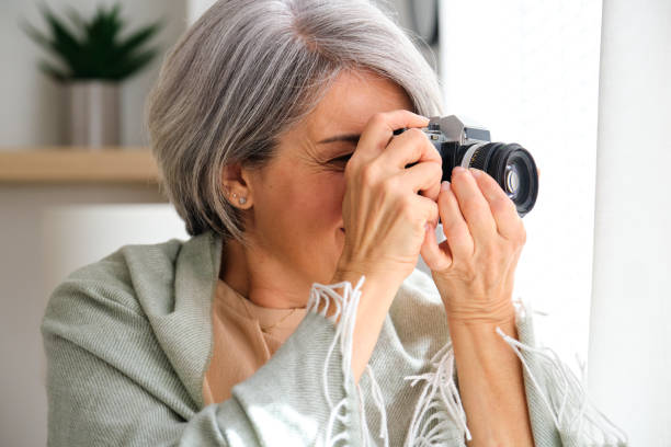 istock A woman is taking a picture with a camera thought the window 2155318765