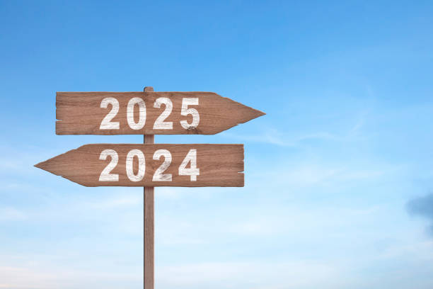 istock An image with a signpost pointing in two different directions in German. One direction points to 2024, the other points to 2025. Future Business concept ideas. 2155323237