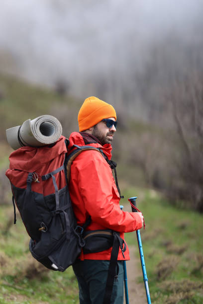 Hiker with backpack ready for journey in park. Mountain tourism