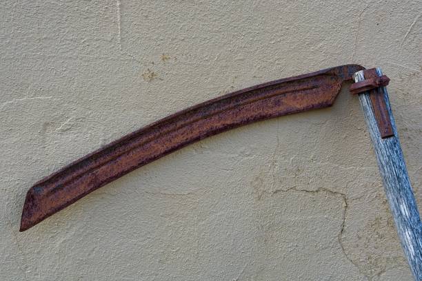 istock Weathered scythe against stucco concrete wall 2155327301