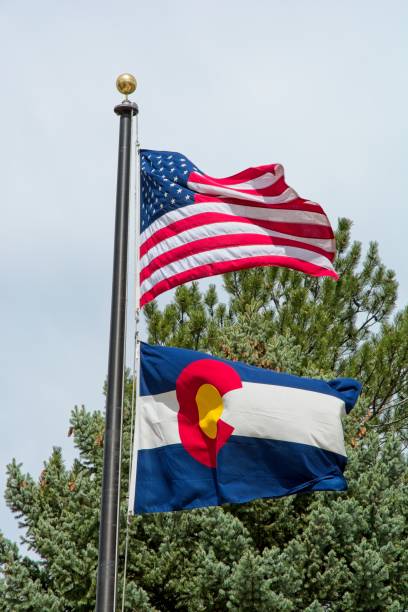 istock Colorado state flag under American flag flying on pole in breeze 2155327343