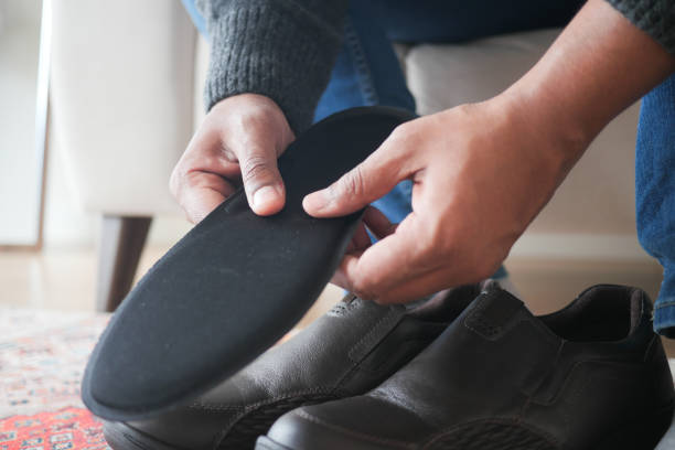 istock men hand putting Orthopedic insoles in shoes 2155330436