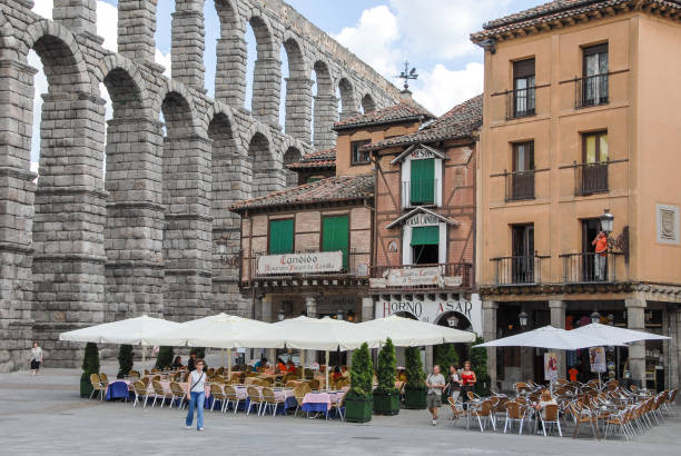 Castilla y Leon, Spain - June 28, 2007: Houses and restaurant terraces in the historic center of Segovia, next to the aqueduct