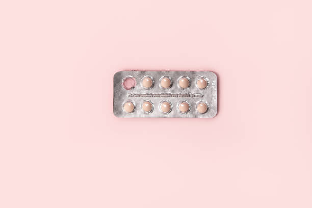 istock Pills in a blister on a pink background. Open pack with one pill missing. 2155334345