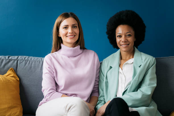 istock Young female business partners sitting together on a sofa 2155334521