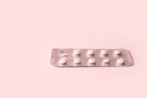 istock Pills in a blister on a pink background. Open pack with one pill missing. 2155334531