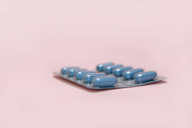 Blue pills in a blister on a pink background