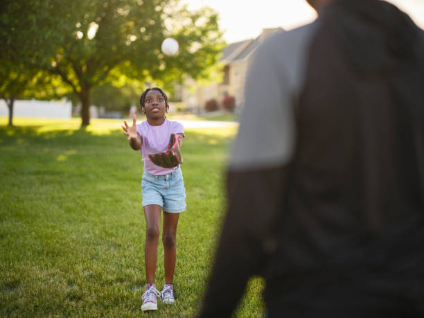 istock Grandfather and Granddaughter Practicing Baseball in a Park 2155340293