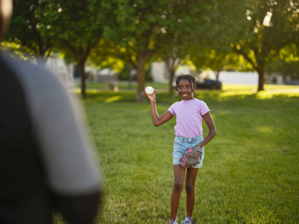 istock Grandfather and Granddaughter Practicing Baseball in a Park 2155340332