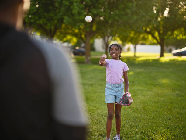 istock Grandfather and Granddaughter Practicing Baseball in a Park 2155340344