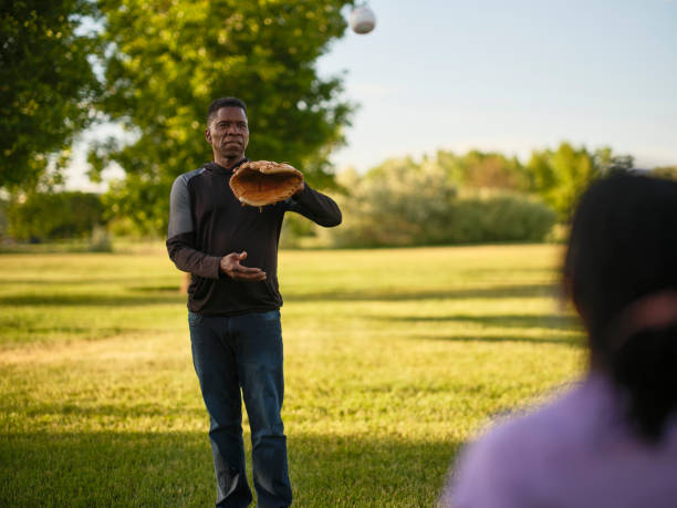 istock Grandfather and Granddaughter Practicing Baseball in a Park 2155340355