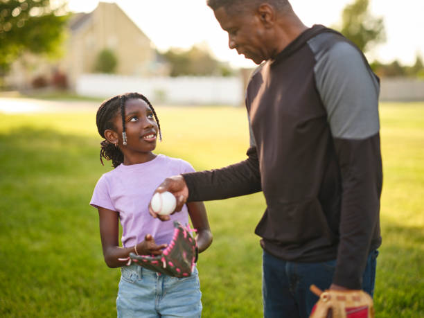 istock Grandfather and Granddaughter Practicing Baseball in a Park 2155340393