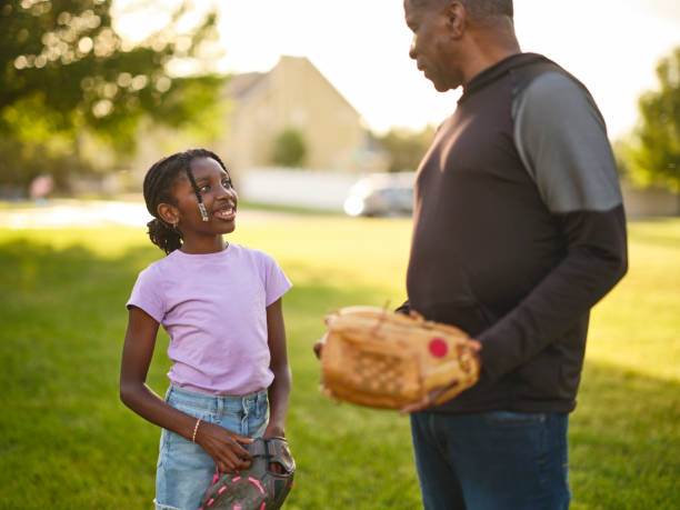 istock Grandfather and Granddaughter Practicing Baseball in a Park 2155340425
