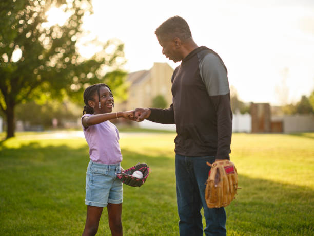 istock Grandfather and Granddaughter Practicing Baseball in a Park 2155340439