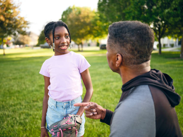 istock Grandfather and Granddaughter Practicing Baseball in a Park 2155340467
