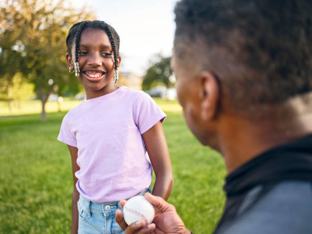istock Grandfather and Granddaughter Practicing Baseball in a Park 2155340501