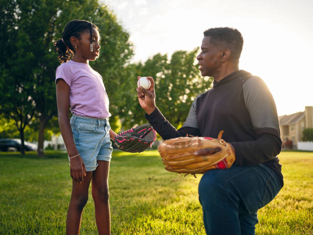 istock Grandfather and Granddaughter Practicing Baseball in a Park 2155340513