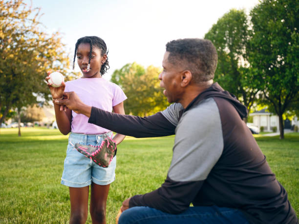 istock Grandfather and Granddaughter Practicing Baseball in a Park 2155340545
