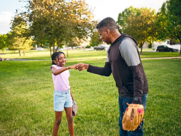 istock Grandfather and Granddaughter Practicing Baseball in a Park 2155340588