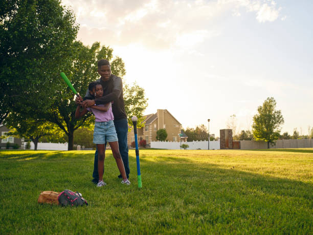 istock Grandfather and Granddaughter Practicing Baseball in a Park 2155340602