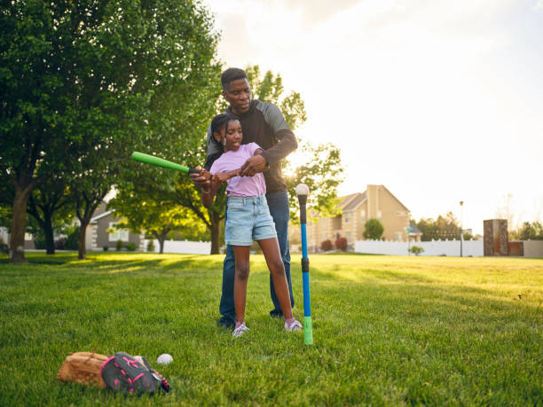 istock Grandfather and Granddaughter Practicing Baseball in a Park 2155340629