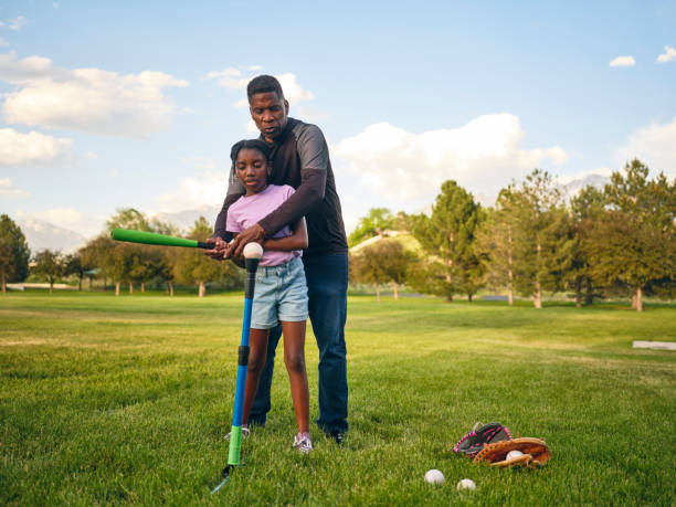 Grandfather and Granddaughter Practicing Baseball in a Park