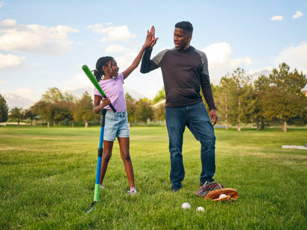 istock Grandfather and Granddaughter Practicing Baseball in a Park 2155340656