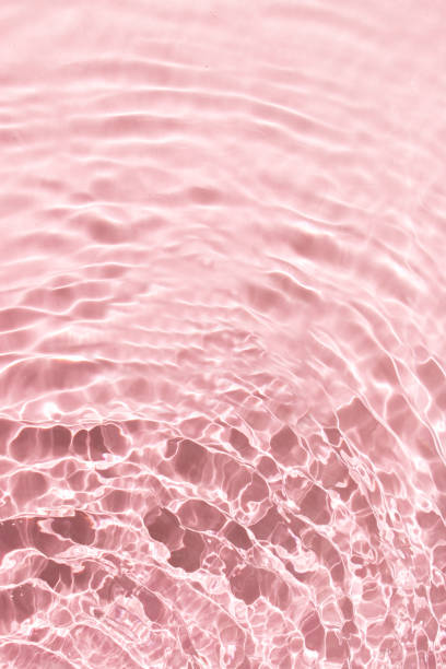 istock Water with shining wave texture on a vibrant pastel pink background. Abstract Water surface background idea. Abstract summer background. 2155342650