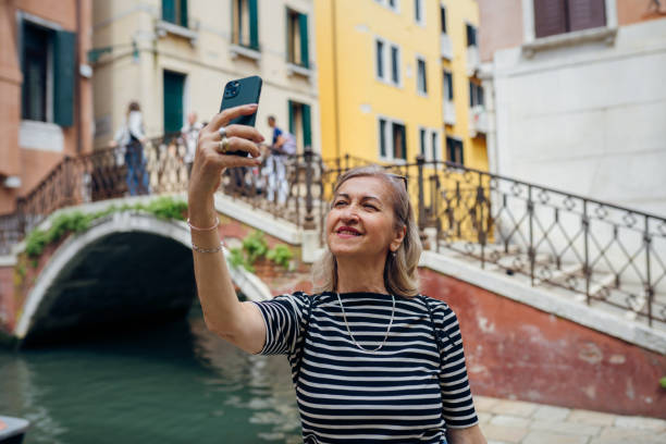 istock Female tourist posing on a canal bridge in Venice 2155346332