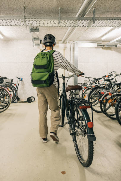 Girl with green backpack going out with her bicycle, morning routine