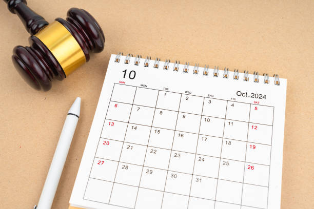 istock Desk calendar for October 2024 and judge's gavel on brown background. 2155351843