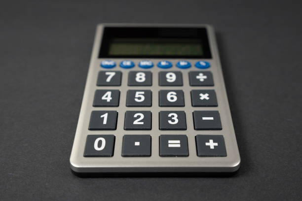 A Calulator Isolated On A Black Desk Photographed Straight On Centered