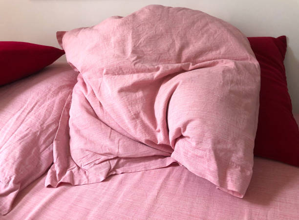 istock France: Rumpled Pink and Red Pillows on Bed Close-Up 2155359546