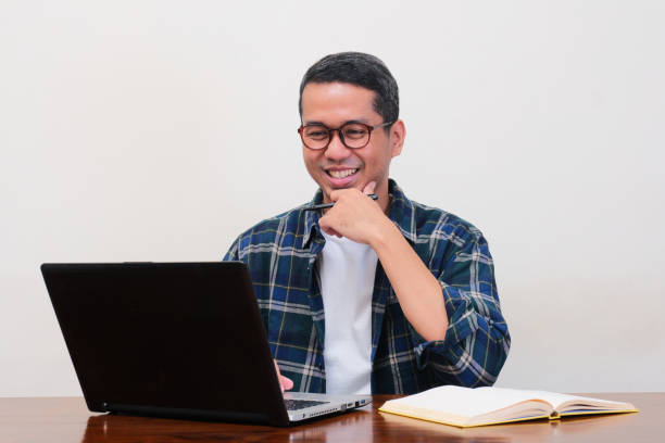 istock A man on workingplace showing happy expression when looking to the laptop 2155360431