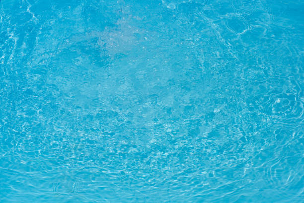 A summer background with a swimming pool, the texture of water on a sunny day.