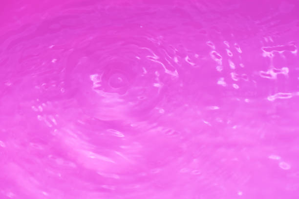 Blue water with ripples on the surface. Defocus blurred transparent blue colored clear calm water surface texture with splashes and bubbles. Water waves with shining pattern texture background.