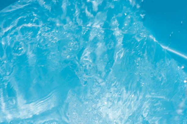 Sunlight dances on the surface of serene blue water, creating gentle ripples. This tranquil scene captures the beauty of nature on a warm afternoon.