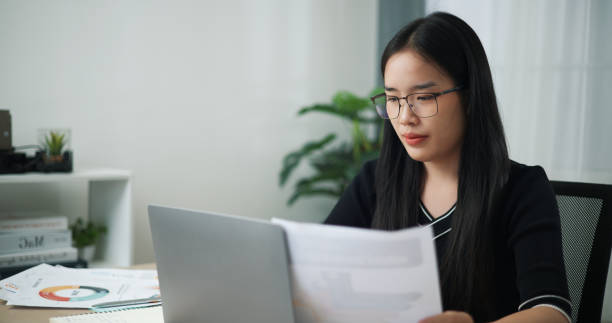 istock Businesswoman reading a document and using computre laptop at the office. 2155368169